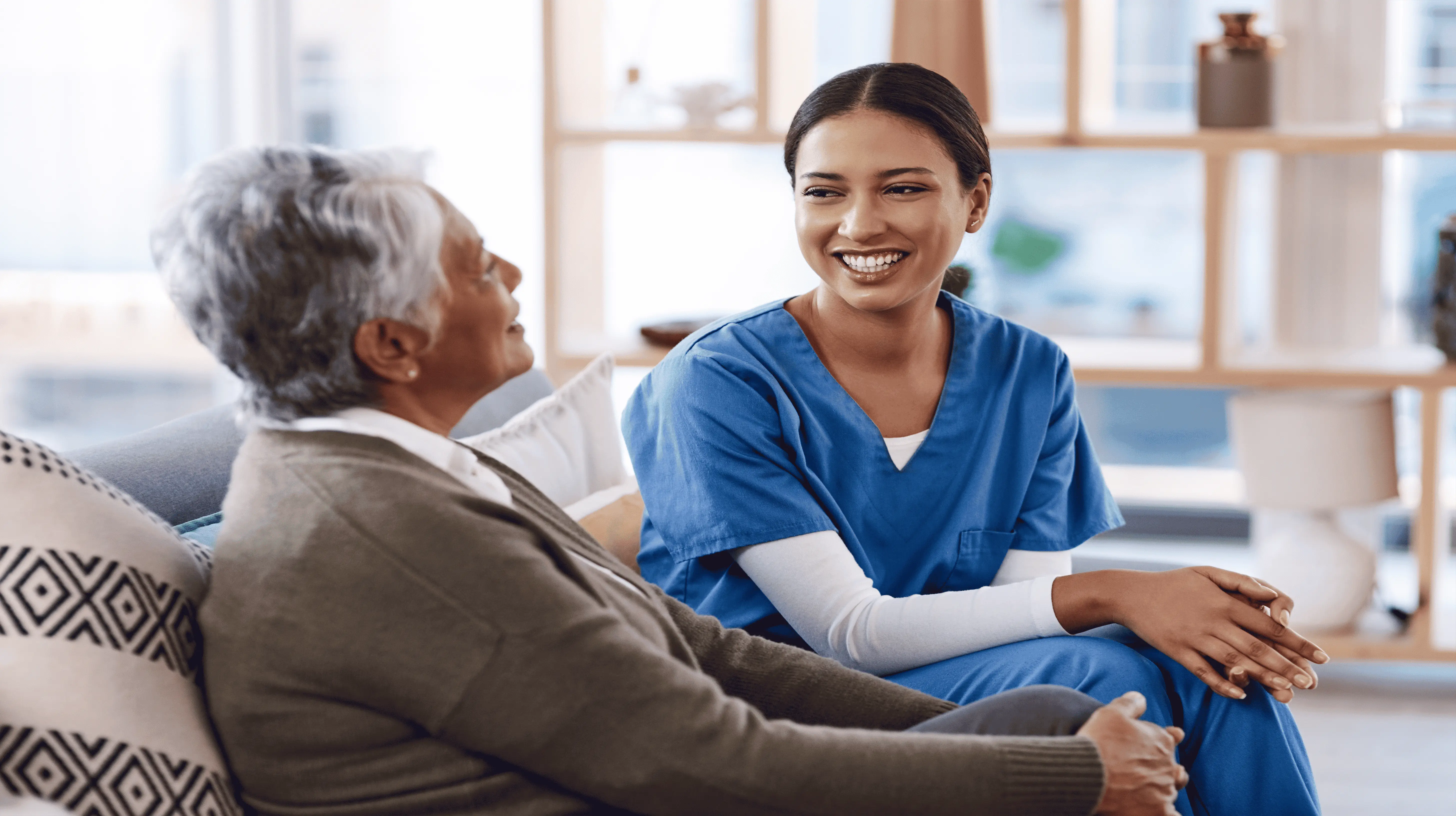 Smiling OC HomeCare caregiver providing compassionate companion care to a senior client in a cozy Dana Point home, promoting dignity and well-being
