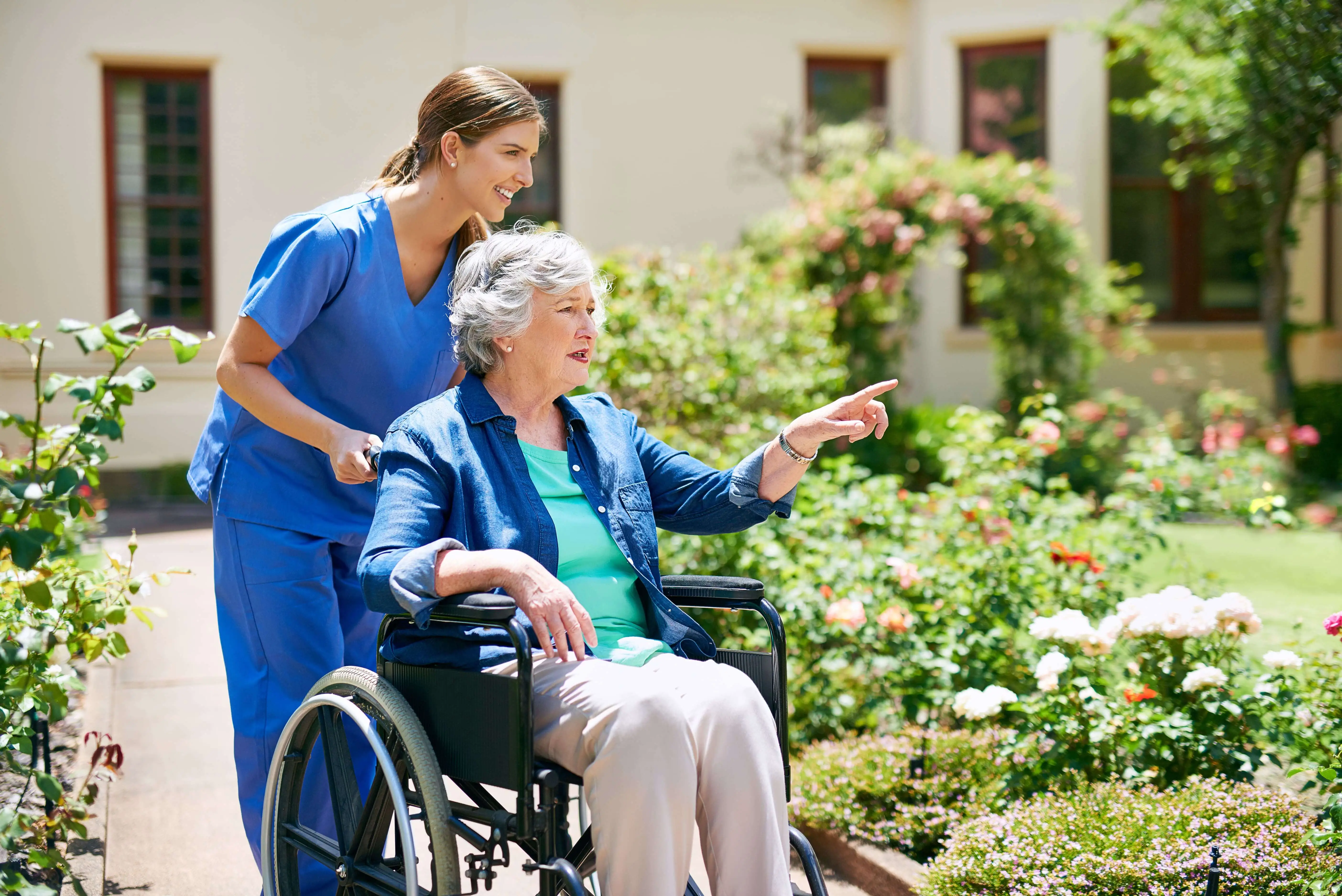 OC HomeCare caregiver assisting a senior in a wheelchair during a peaceful walk in Cypress, CA – offering trusted mobility support and companionship